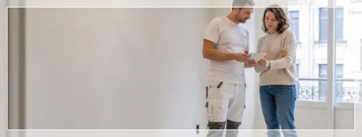 Peintre et propriétaire préparant la rénovation d’un appartement