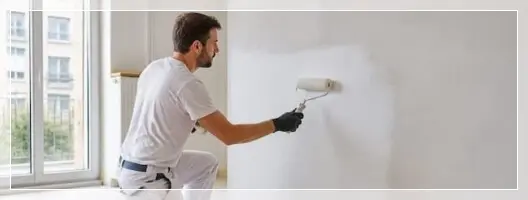 Peintre appliquant un primaire après un dégât des eaux